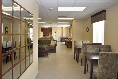 A conference room with a glass wall and a long table with chairs.