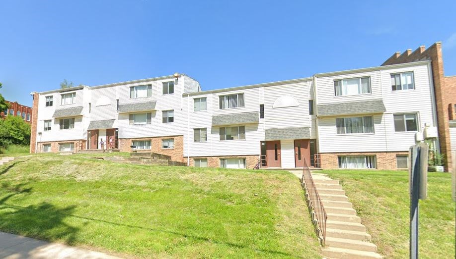 A row of townhouses with a grassy front yard.
