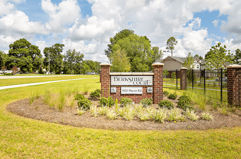 A sign that says Brookhurst Court stands in a field of flowers.