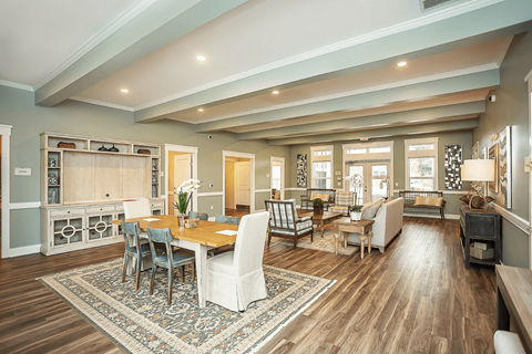 A spacious living room with a dining table and chairs.