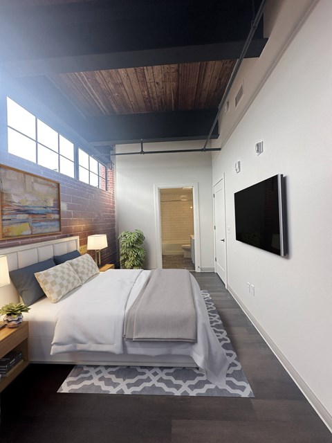 a bedroom with a bed and a tv on the wall at The Mill at Prattville, Alabama