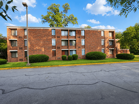 A large brick building with a parking lot in front.