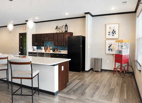 A kitchen with a black refrigerator and a white countertop.