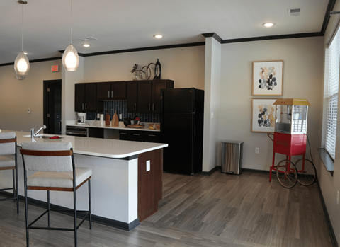 A kitchen with a white counter and a black fridge.