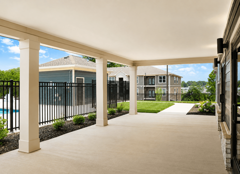A covered walkway leads to a pool and houses.