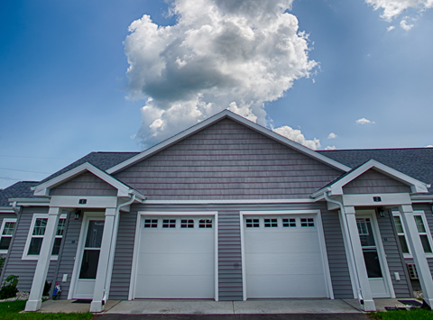 A house with two garages and a grey roof.