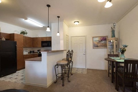 A kitchen with a white counter and a black refrigerator.