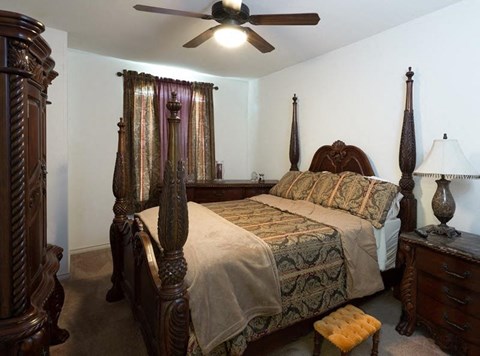 a bedroom with a bed and a ceiling fan