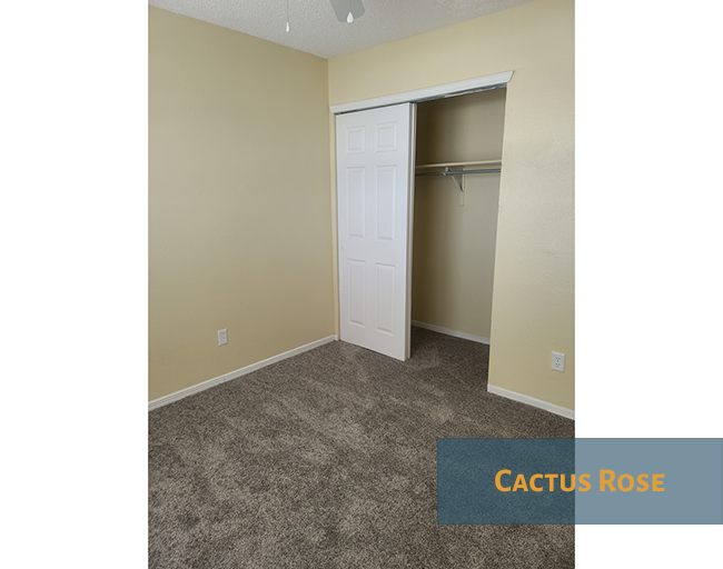 A room with a white door and a carpeted floor.