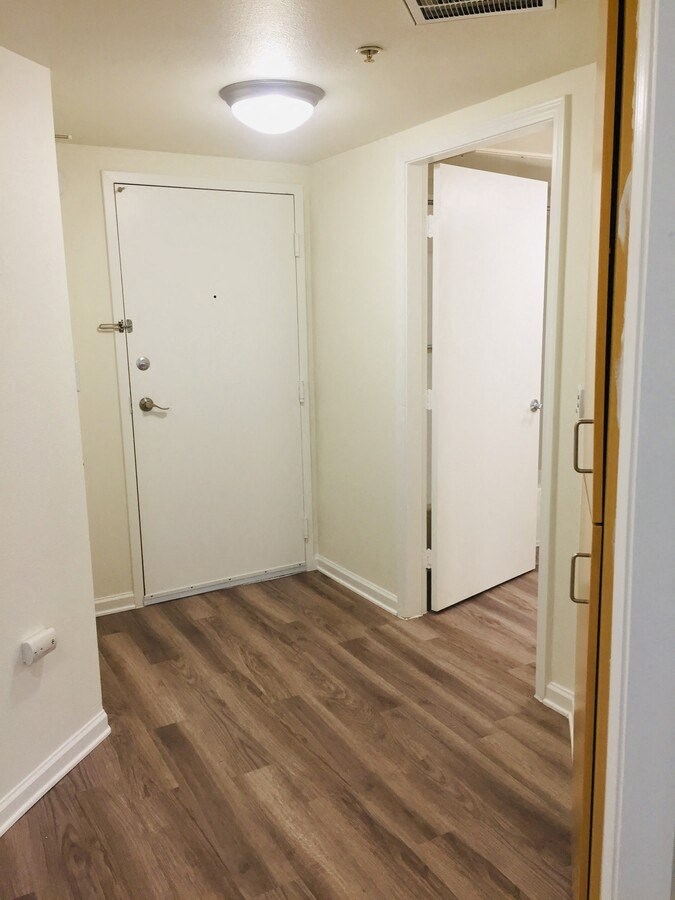 an empty room with white walls and a wooden floor