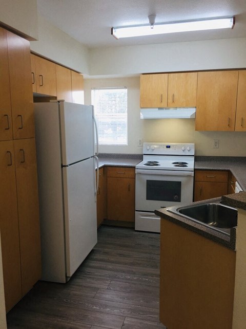 a kitchen with white appliances and wooden cabinets