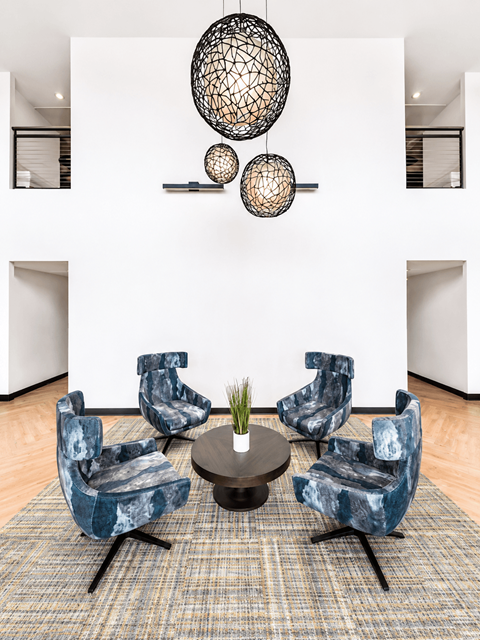 A living room with a white wall and a set of blue chairs.
