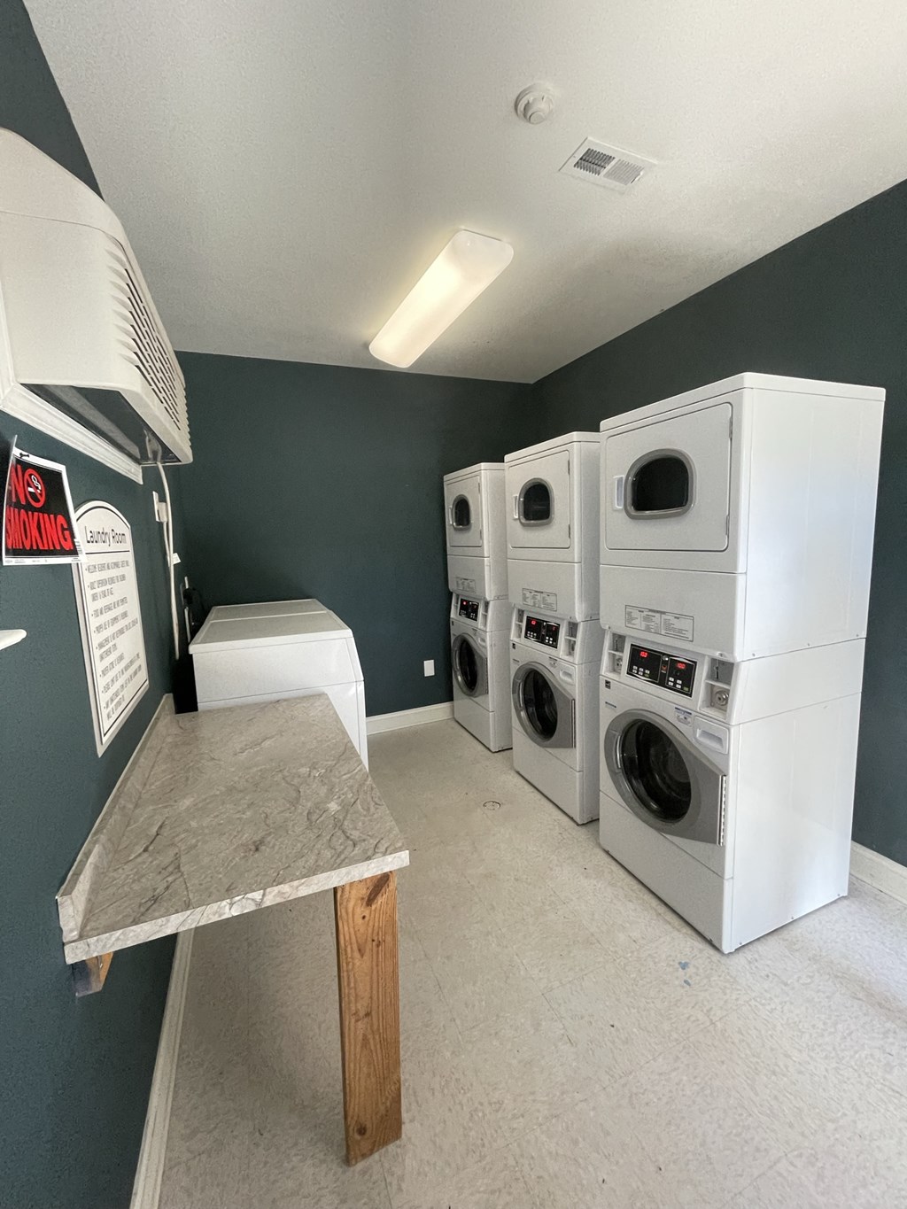 a laundry room with four washes and a table with a bench