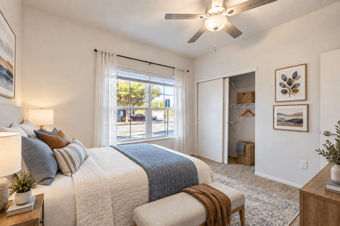 A bedroom with a large bed and a ceiling fan.