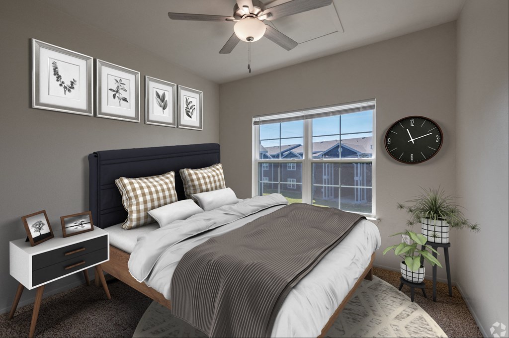 A bedroom with a bed, nightstand, and a window with a view of buildings outside.