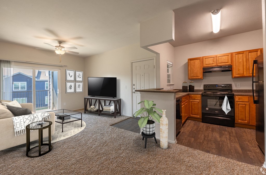 A living room with a couch, a television, and a kitchen area with a stove and refrigerator.