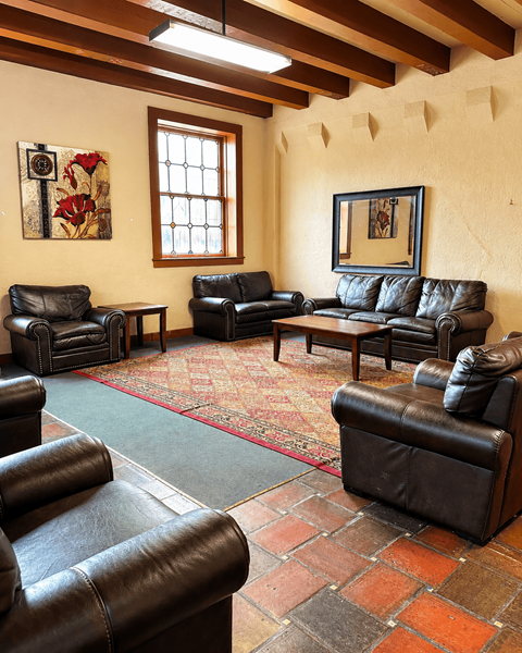 A living room with leather couches and a rug.
