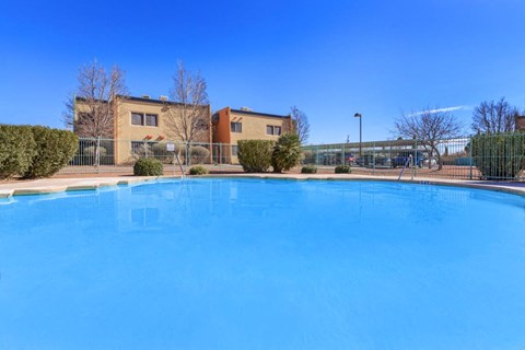 A large blue swimming pool in front of a building.