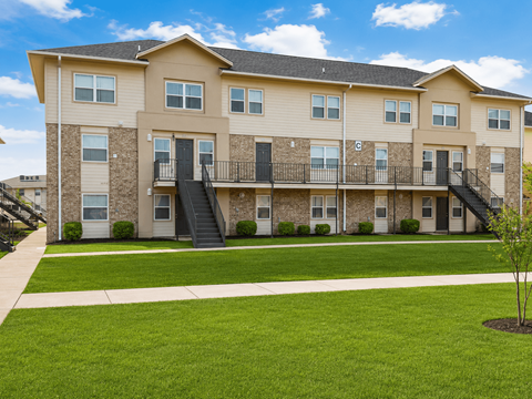 A large apartment building with a balcony on the second floor.