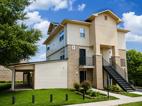 A two-story house with a balcony and a staircase leading to the second floor.