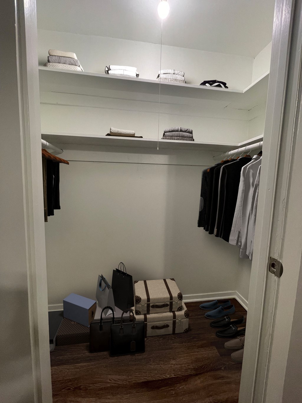 a walk in closet with luggage and clothes on shelves at The Junction, Memphis, TN