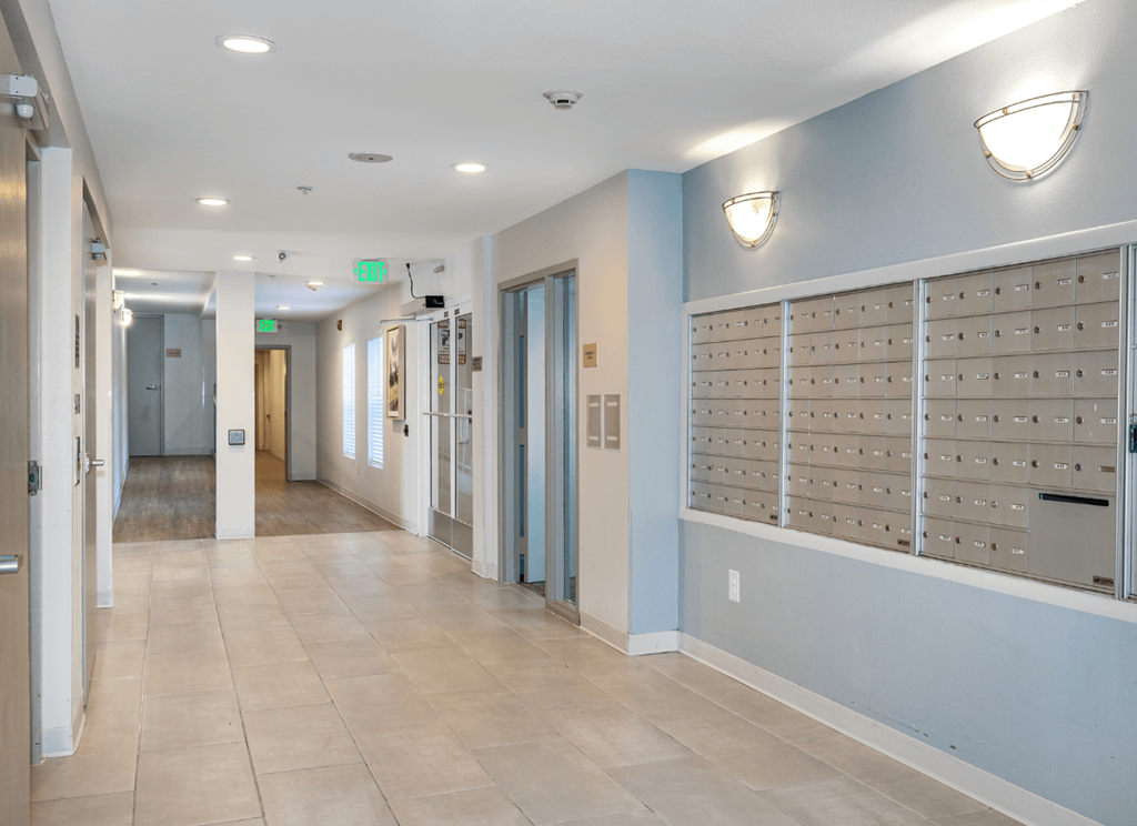 A hallway with a row of mailboxes on the wall.