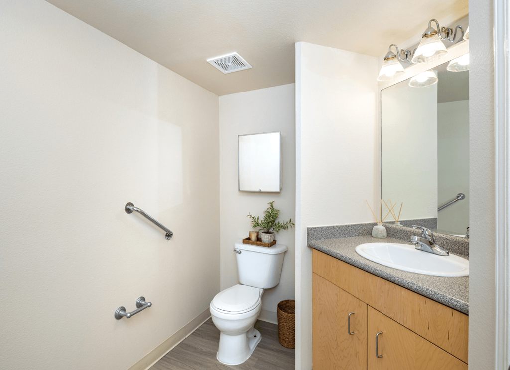 A white toilet sits in a bathroom next to a sink.
