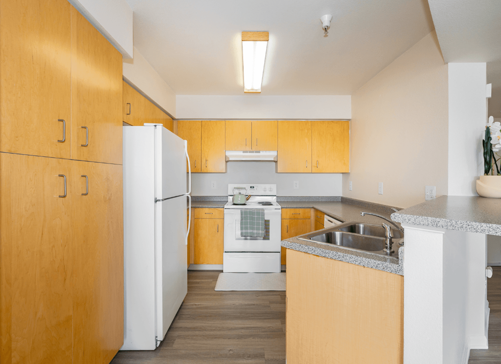 A kitchen with wooden cabinets and a white refrigerator.