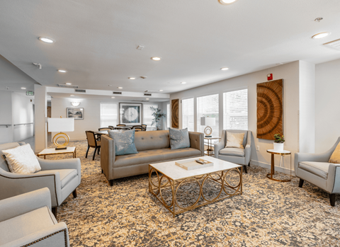 A living room with a patterned carpet and a large window.