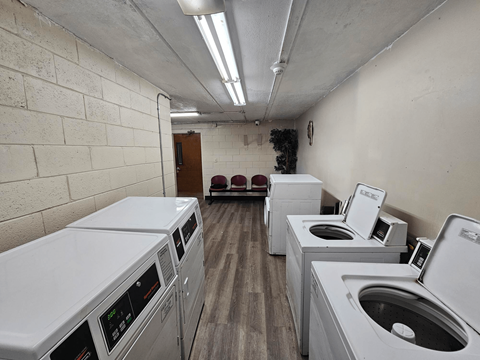an empty laundry room with washing machines and dryers