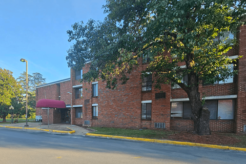 a large brick building with a tree in front of it