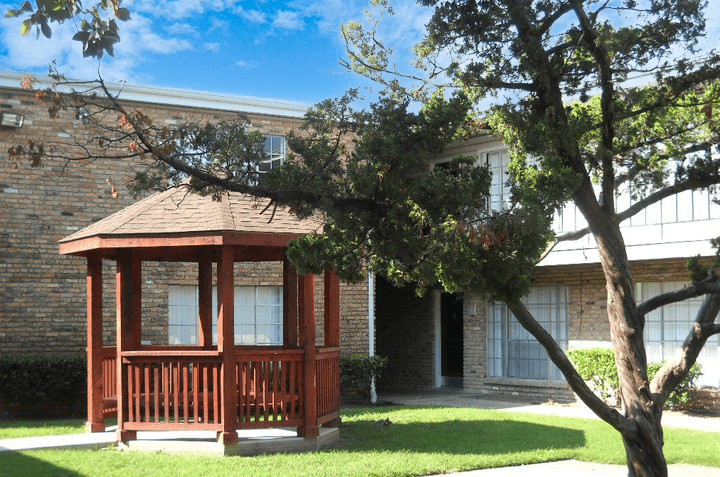 a small screened porch in front of a brick house