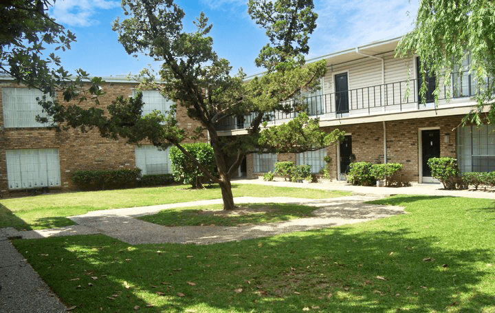 an exterior view of a building with a lawn and trees