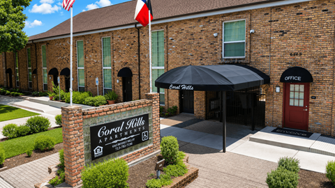 A brick building with a sign that says "Coral Hills Apartment".