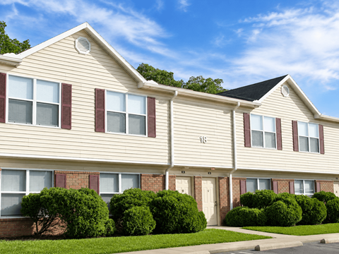 A row of houses with green bushes in front.