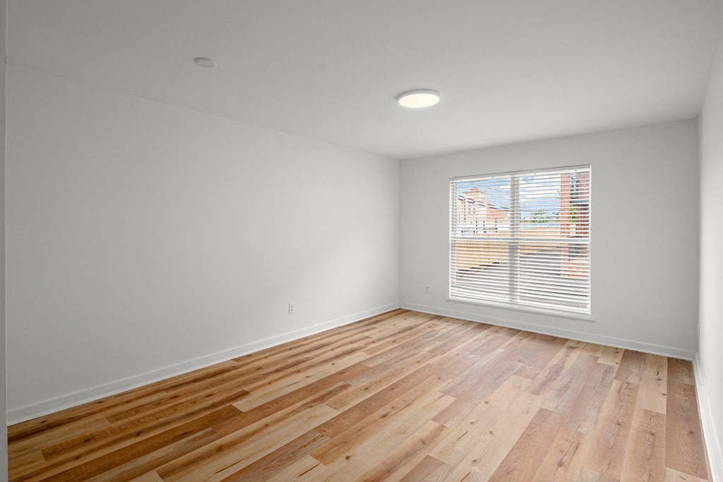 an empty room with wood floors and a window at The Courts Midtown, Memphis, 38104