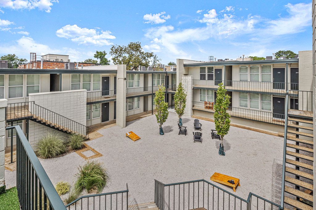 a courtyard area with benches and trees in front of apartment buildings at The Courts Midtown, Memphis