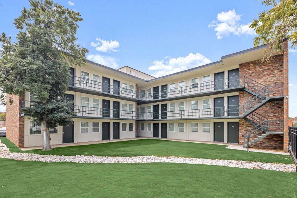 an exterior view of an apartment building with grass and trees at The Courts Midtown, Memphis
