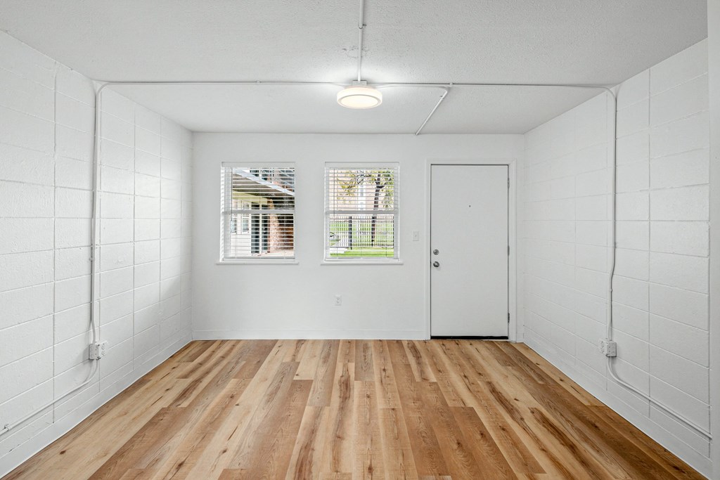 an empty room with white walls and wood floors at The Courts Midtown, Memphis, TN