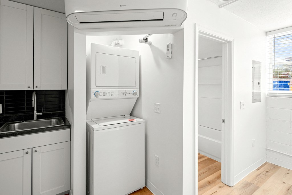 a kitchen with a washer and dryer and a white refrigerator at The Courts Midtown, Memphis, Tennessee