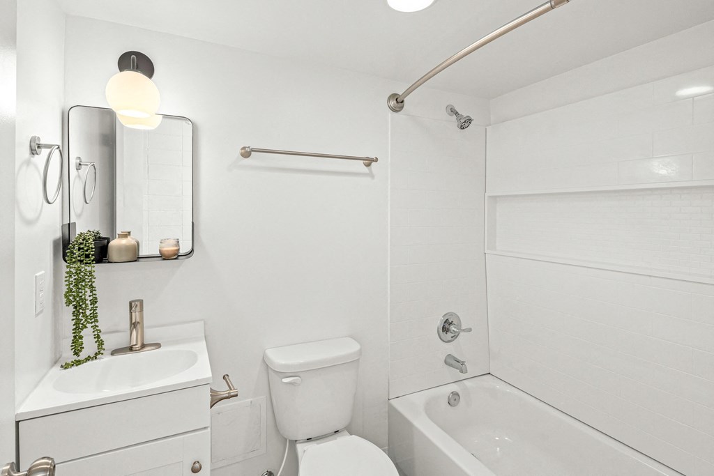 a white bathroom with a white toilet and a tub and a sink at The Courts Midtown, Memphis, TN, 38104