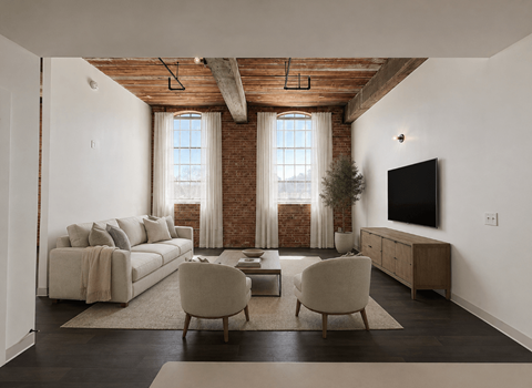 A living room with a couch, chairs, and a television.