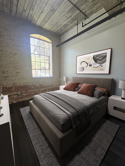 A bedroom with a bed, nightstand, and a window with a view of a fence and trees.