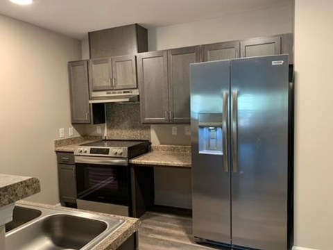 A kitchen with a stainless steel refrigerator, oven, and dishwasher.