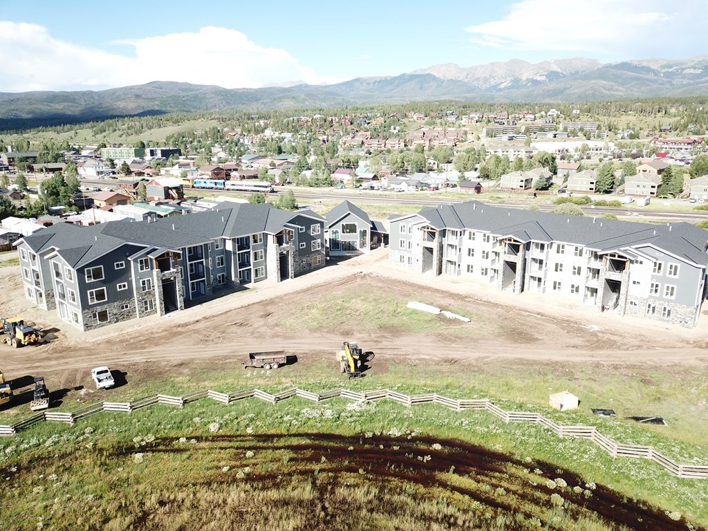 a row of houses under construction on a grassy hill