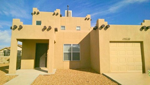 A beige house with a garage door and a window.