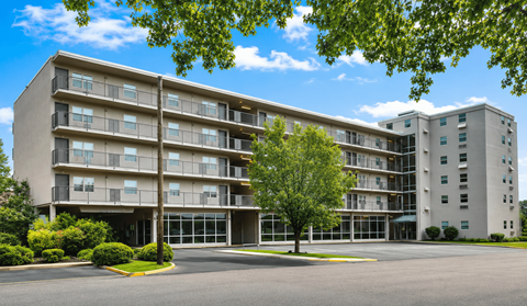 A large apartment building with a parking lot in front.