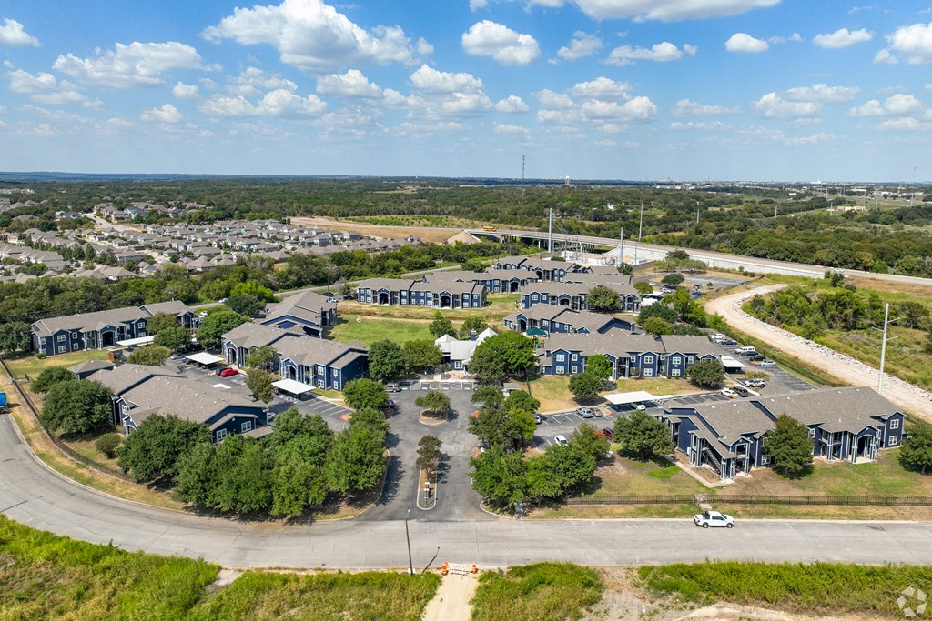 A large, modern building complex with a parking lot in front.