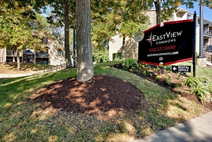 A sign for EastView Commons rental apartments is displayed in a grassy area.