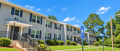 Apartment building with a blue sign in front.